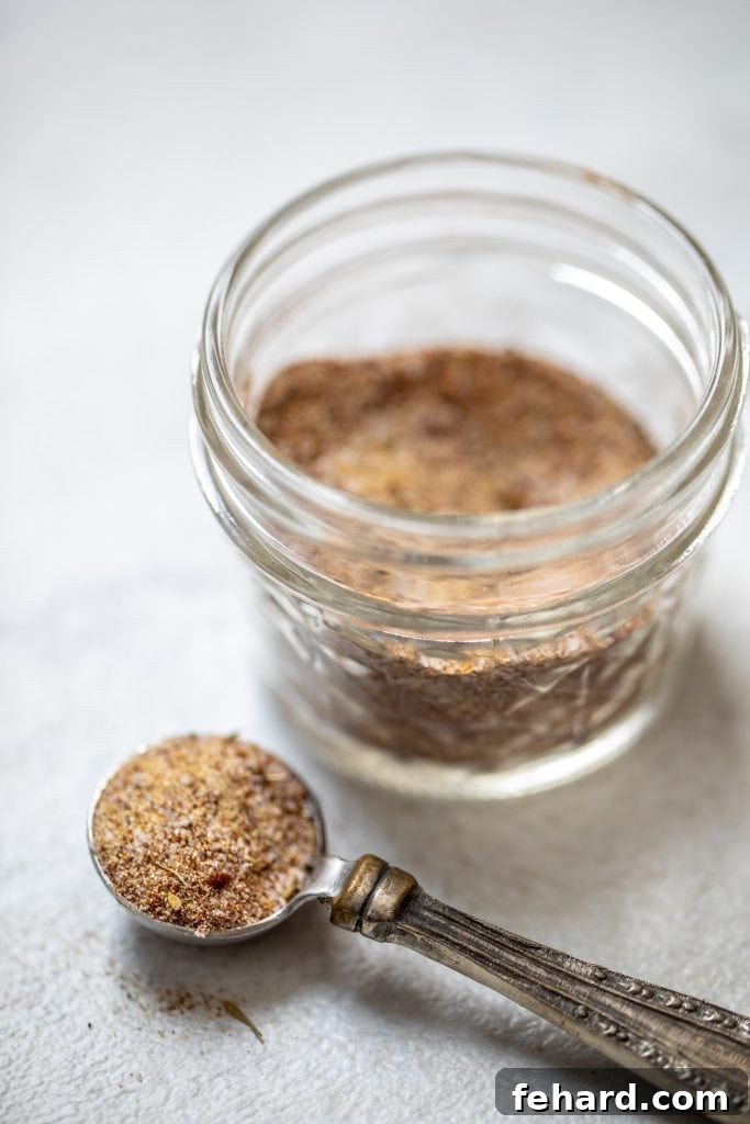 Glass jar of homemade jerk seasoning, ready for use.