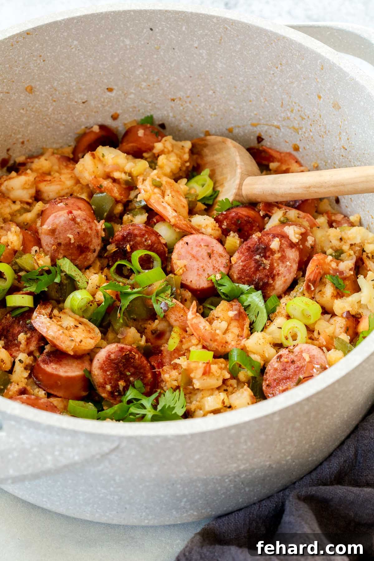 Cooking Whole30 Jambalaya in One Pot for Easy Cleanup An overhead view of a large white pot filled with a steaming Whole30 jambalaya, ready to be served.