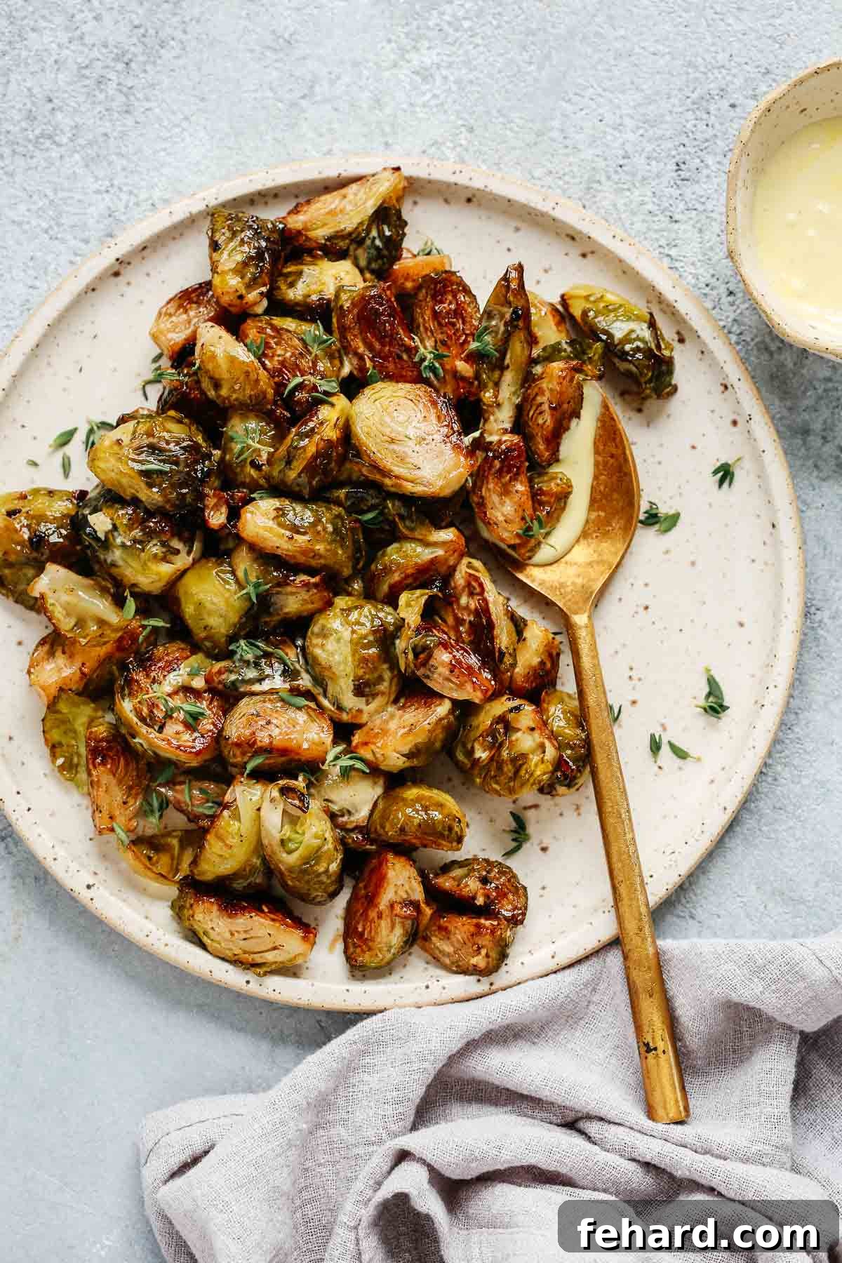 Crispy Brussels Sprouts with Tangy Mustard Mayo 2 Overhead view of perfectly roasted Brussels sprouts on a white serving platter, ready to be enjoyed as a healthy and flavorful side dish for any holiday meal.
