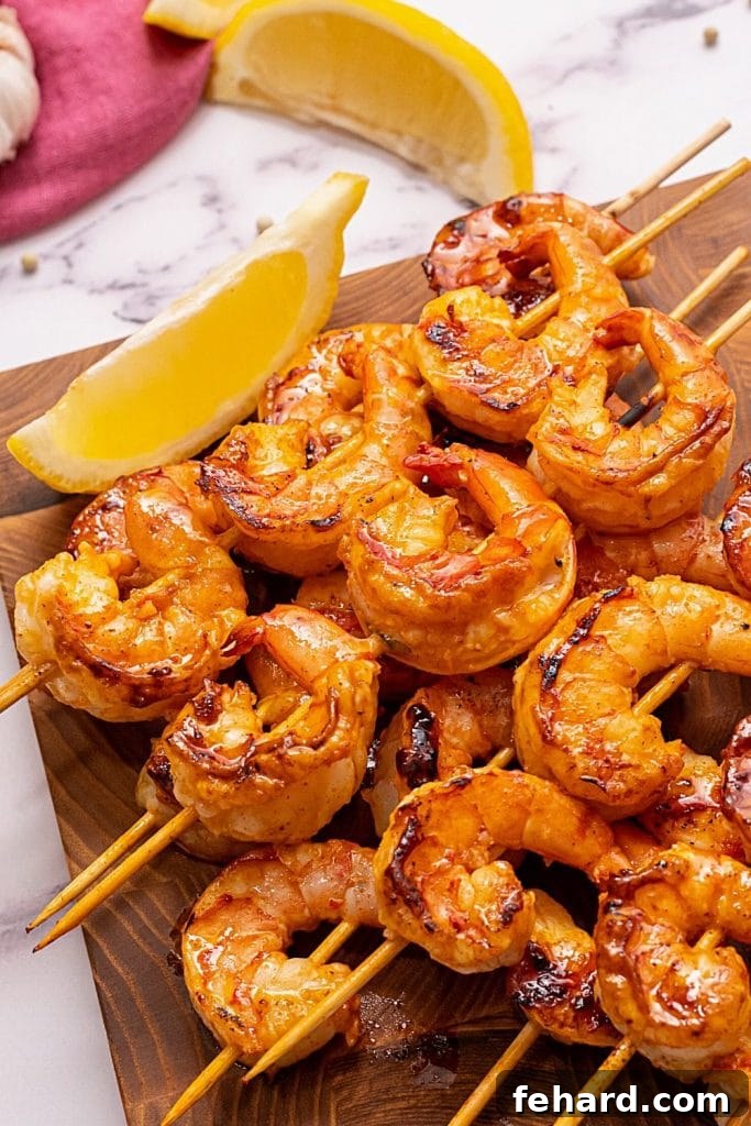 Perfectly grilled shrimp skewers garnished with fresh lemon wedges, ready to serve.
