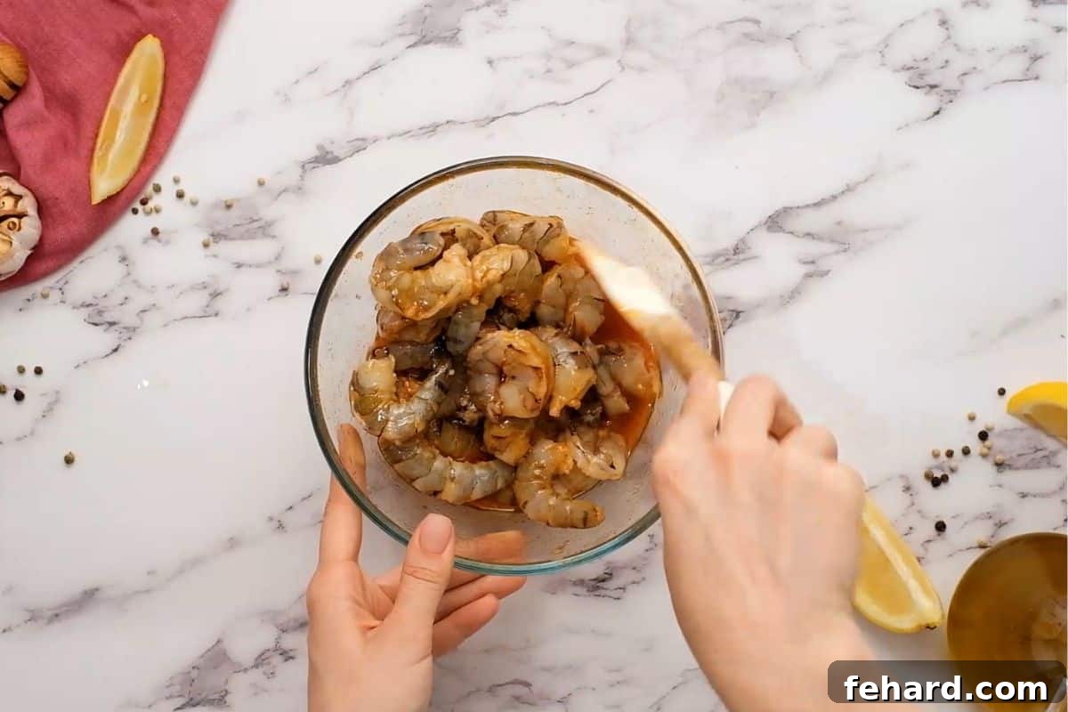 Raw jumbo shrimp being tossed in a vibrant honey lemon garlic marinade, ready for grilling.