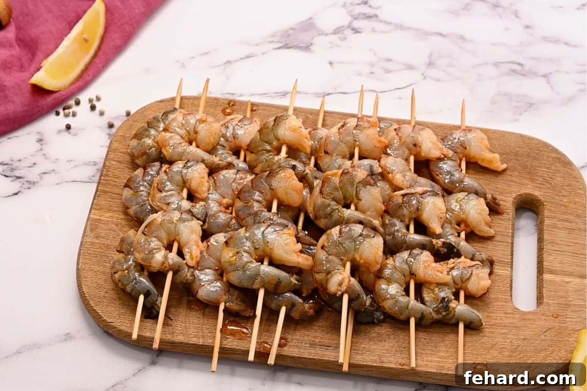 Marinated shrimp carefully threaded onto wooden skewers, arranged on a cutting board, ready for the grill.