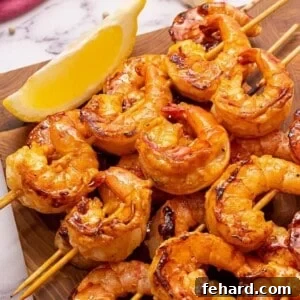 Photo of grilled shrimp next to lemon wedge.