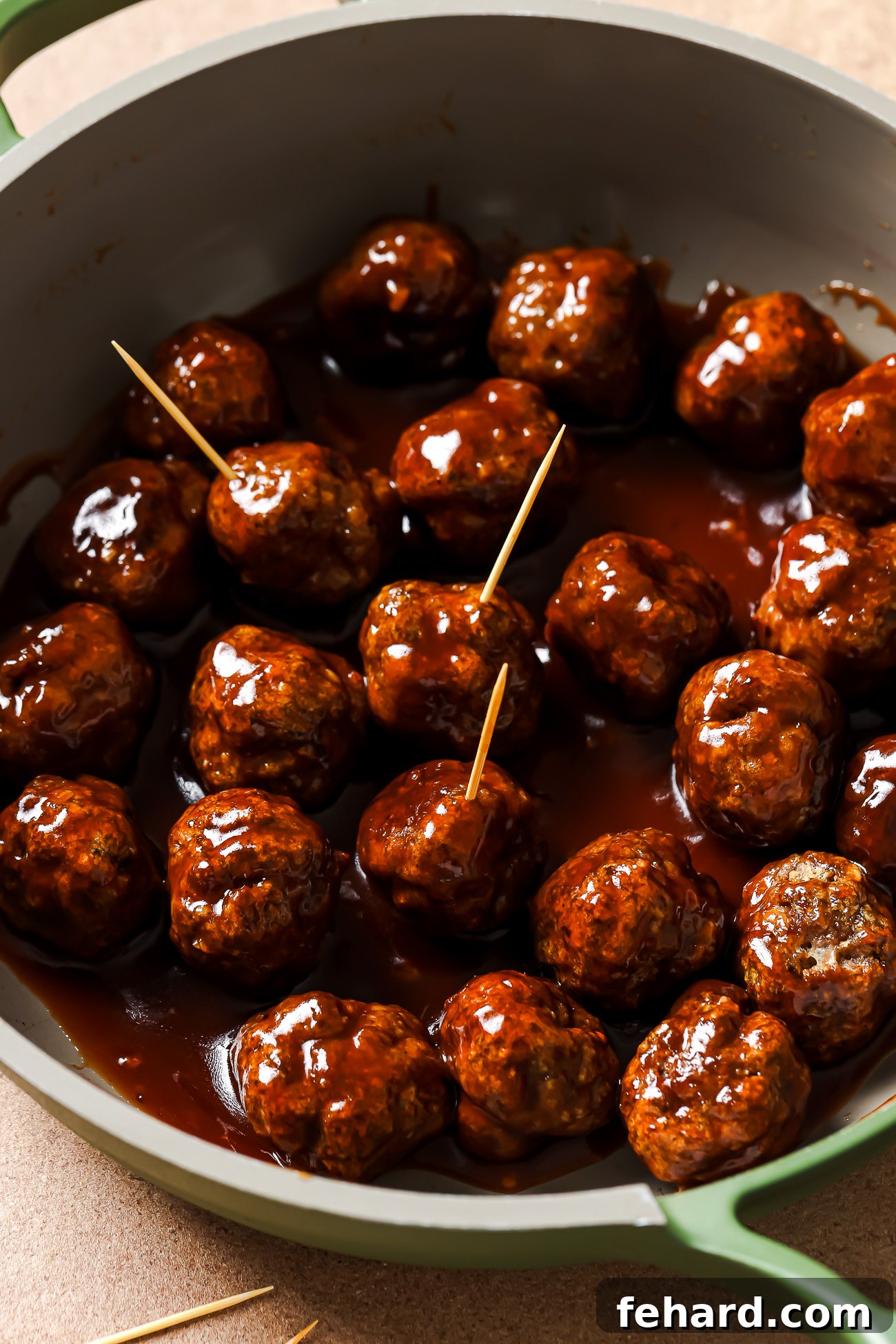 Irresistible Party Meatballs 10 cocktail meatballs on a skillet.