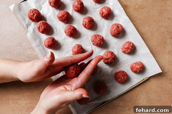 Irresistible Party Meatballs 6 Hands rolling the mixture to form meatballs.