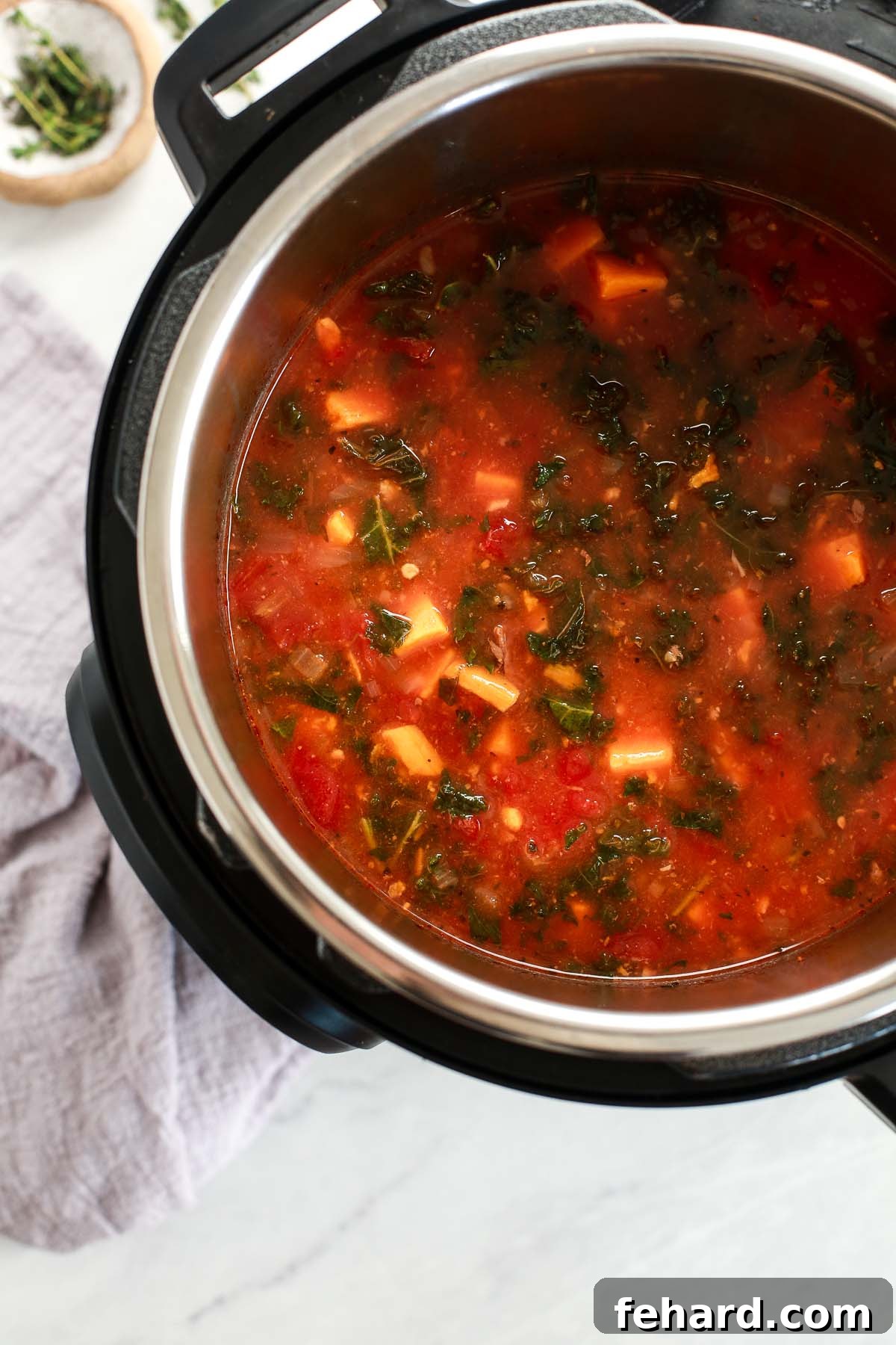 Instant Pot filled with Sweet Potato Kale Beef Soup ingredients before pressure cooking, showcasing the convenience of one-pot preparation.