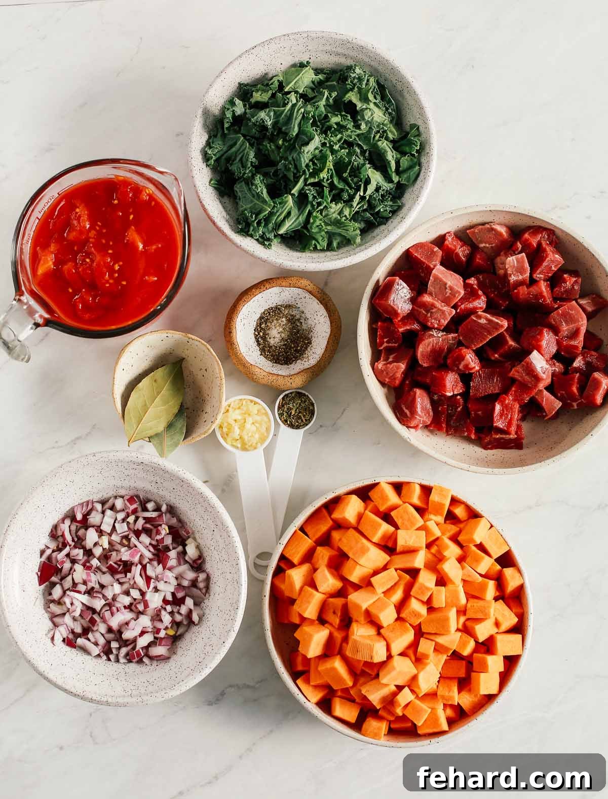 A visual guide displaying all the fresh, wholesome ingredients required for Instant Pot Sweet Potato Kale Beef Soup, arranged on a rustic wooden board.