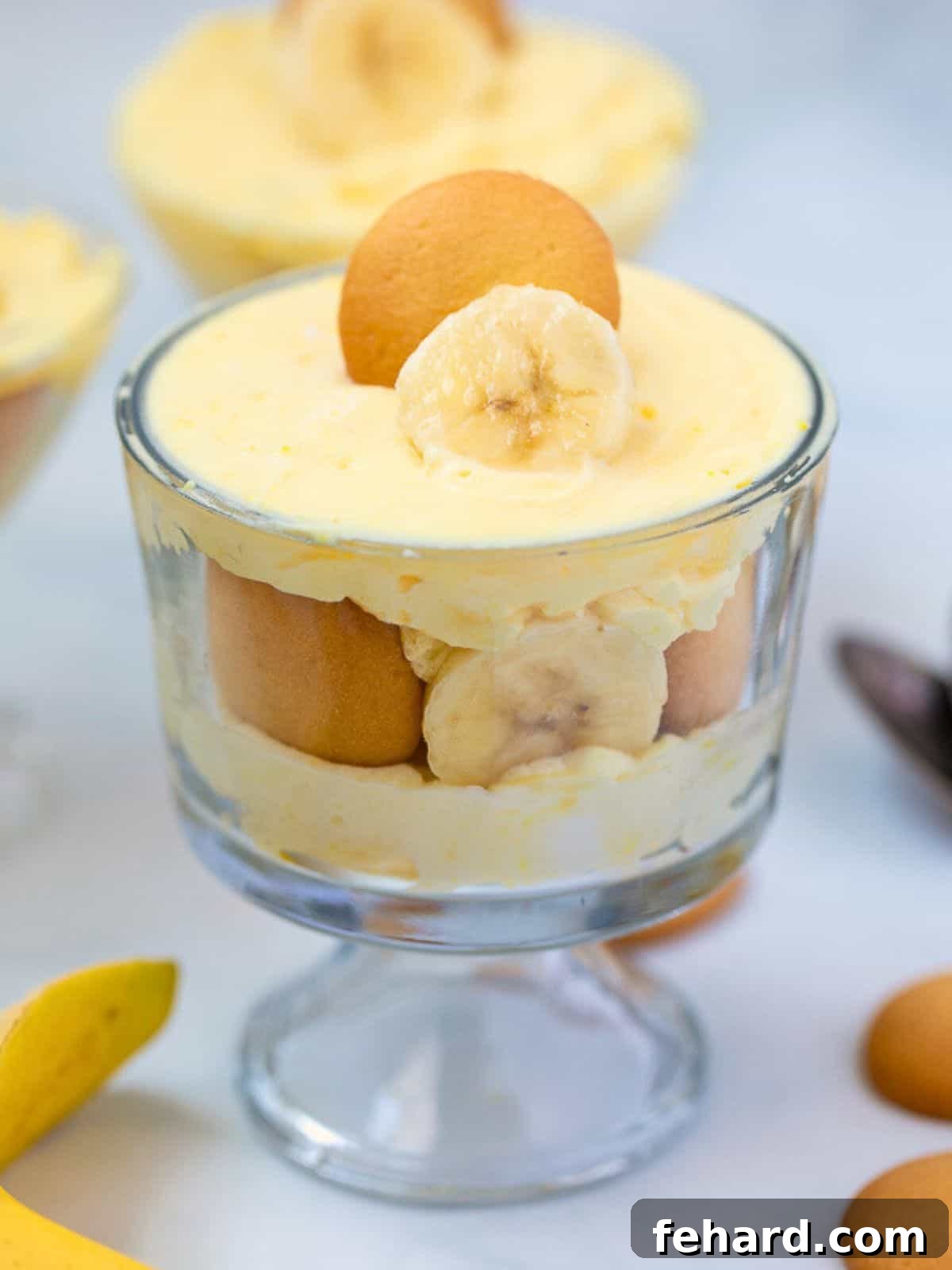 Banana Pudding layered in mini trifle cups with vanilla wafers and banana slices, ready to serve.