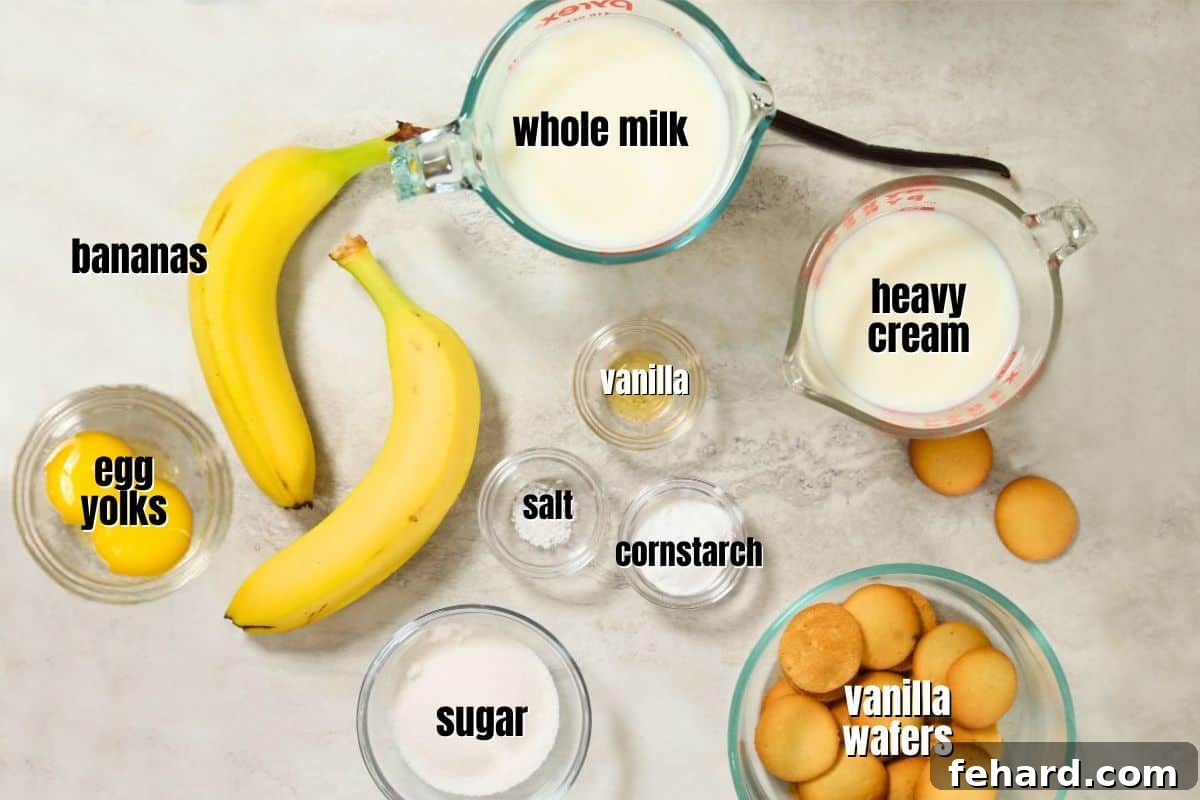 Ingredients for classic homemade banana pudding laid out on a kitchen counter: milk, sugar, cornstarch, eggs, vanilla, heavy cream, bananas, lemon juice, and vanilla wafers.