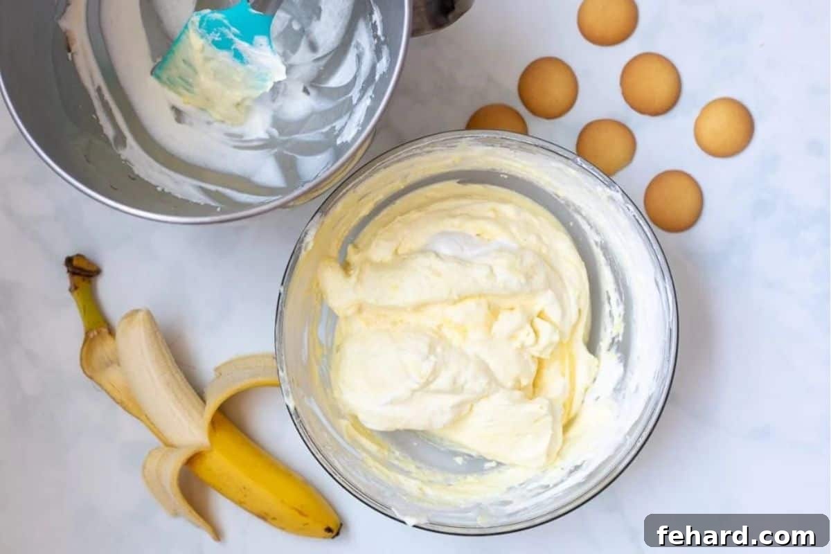 Homemade vanilla pudding being gently folded with fresh whipped cream to create a light and airy texture.