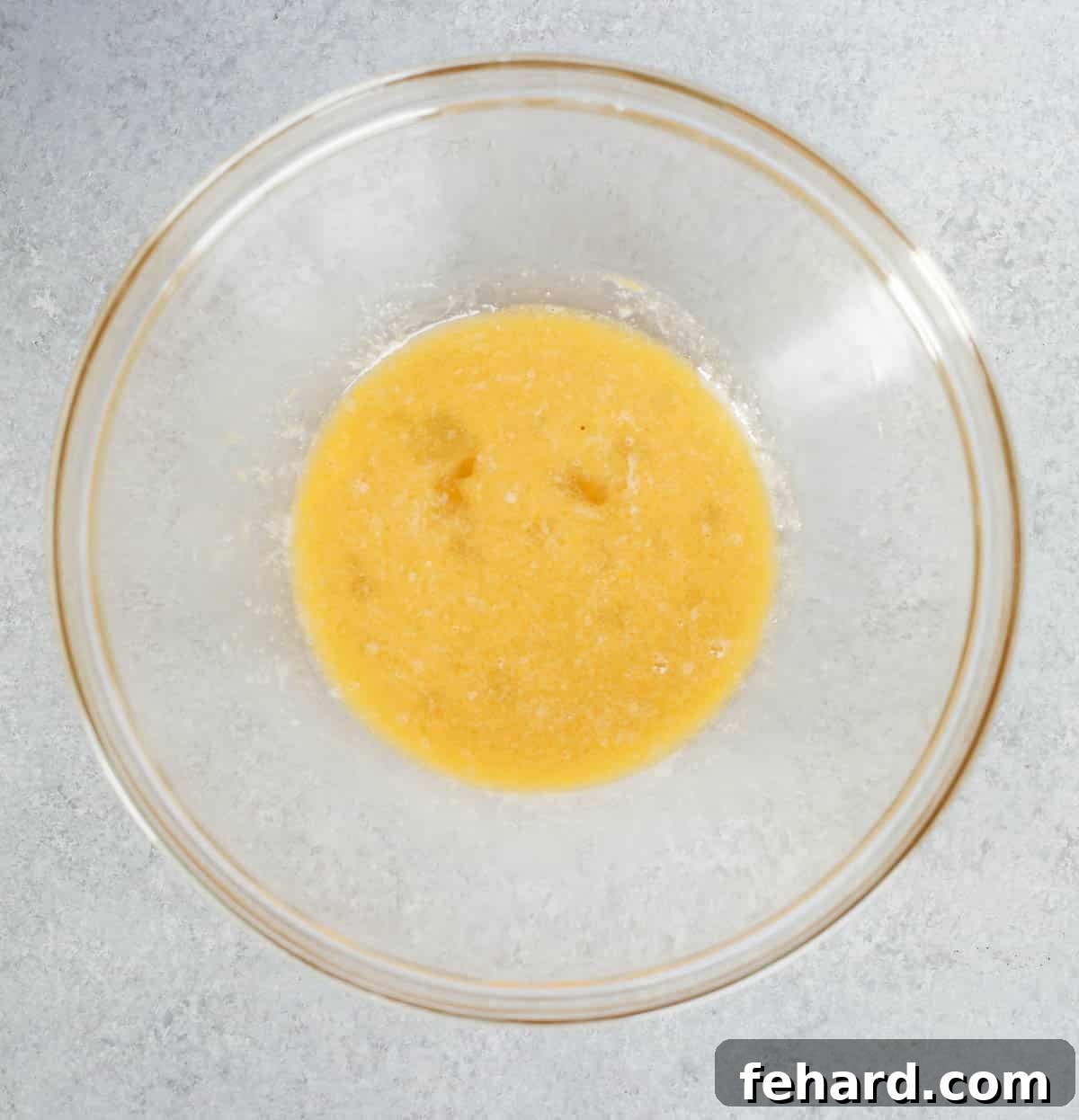 Smooth mixture of wet ingredients for hazelnut cookies in a clear glass bowl.