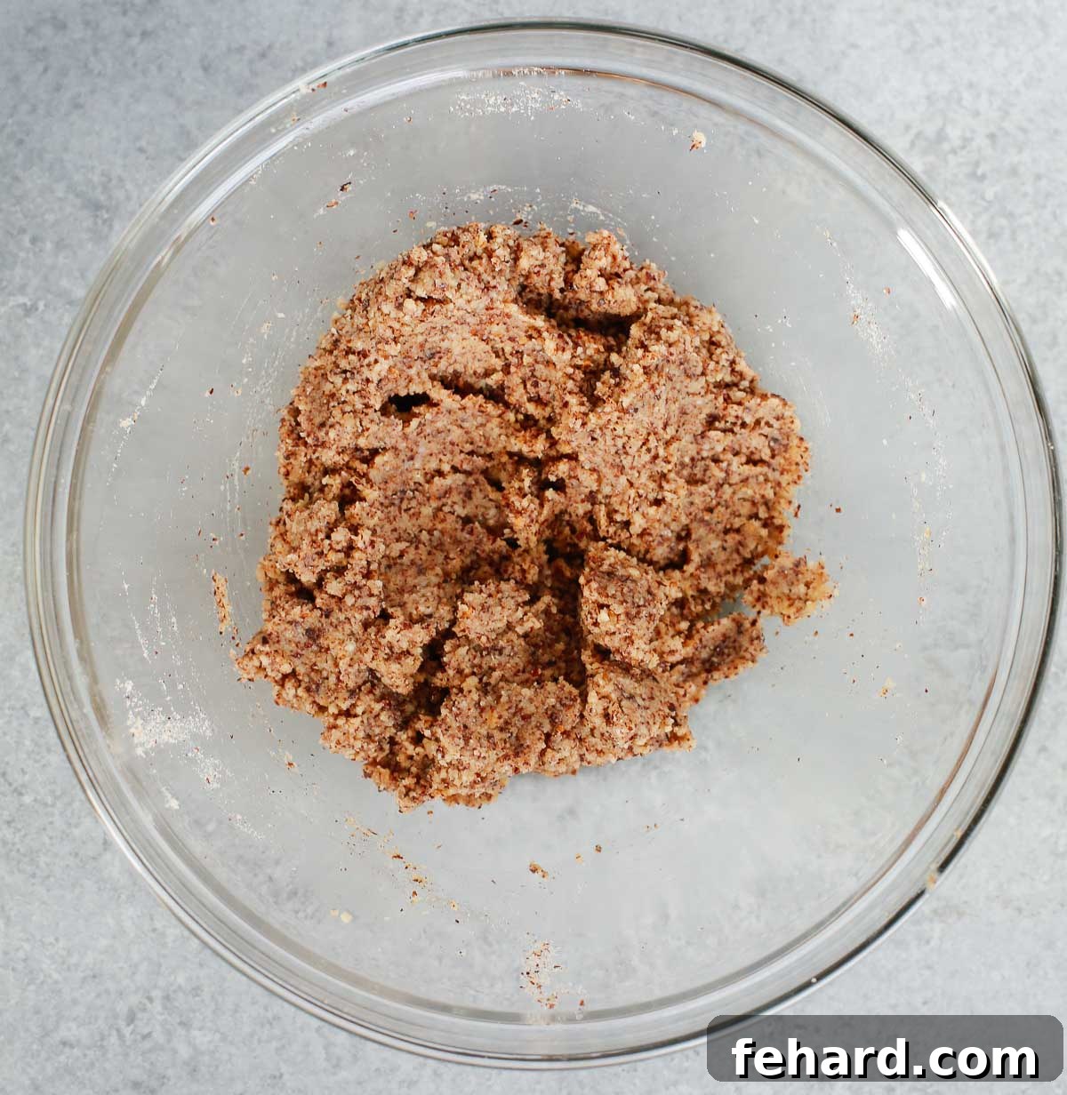 Cookie dough mixed in a glass bowl, ready for chocolate chunks.