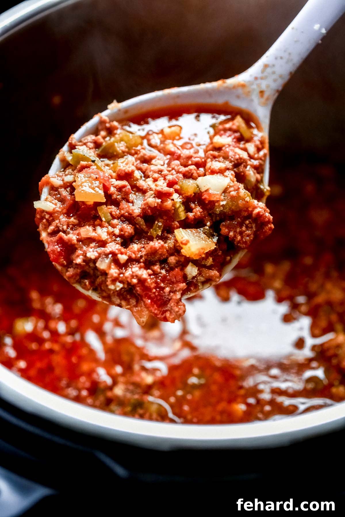 Ultimate Instant Pot Keto Chili 3 close up of chili on a spoon held over a pot
