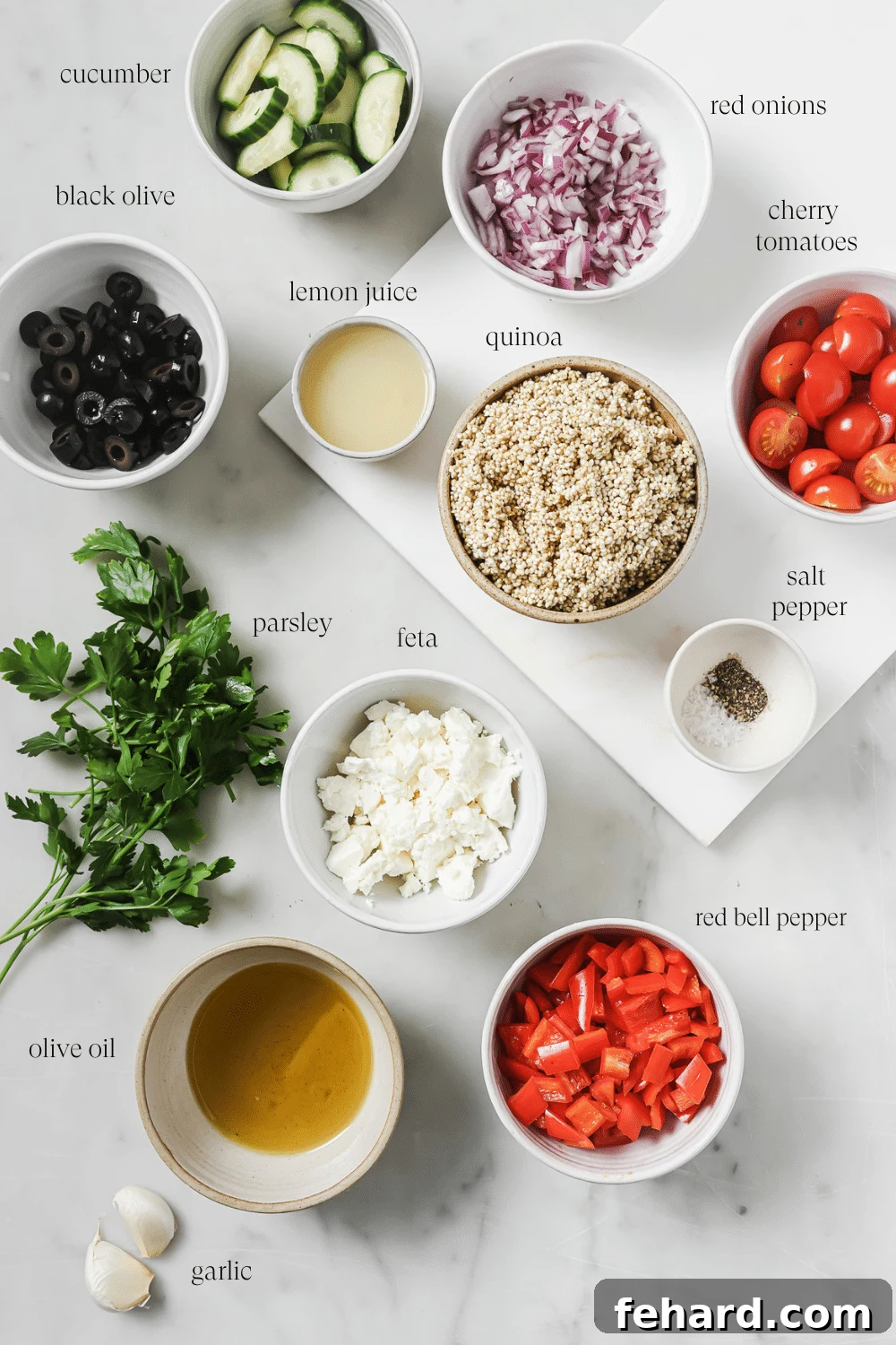 Vibrant Greek Quinoa Salad 3 An organized display of pre-measured ingredients for Greek quinoa salad, neatly arranged in small white bowls.