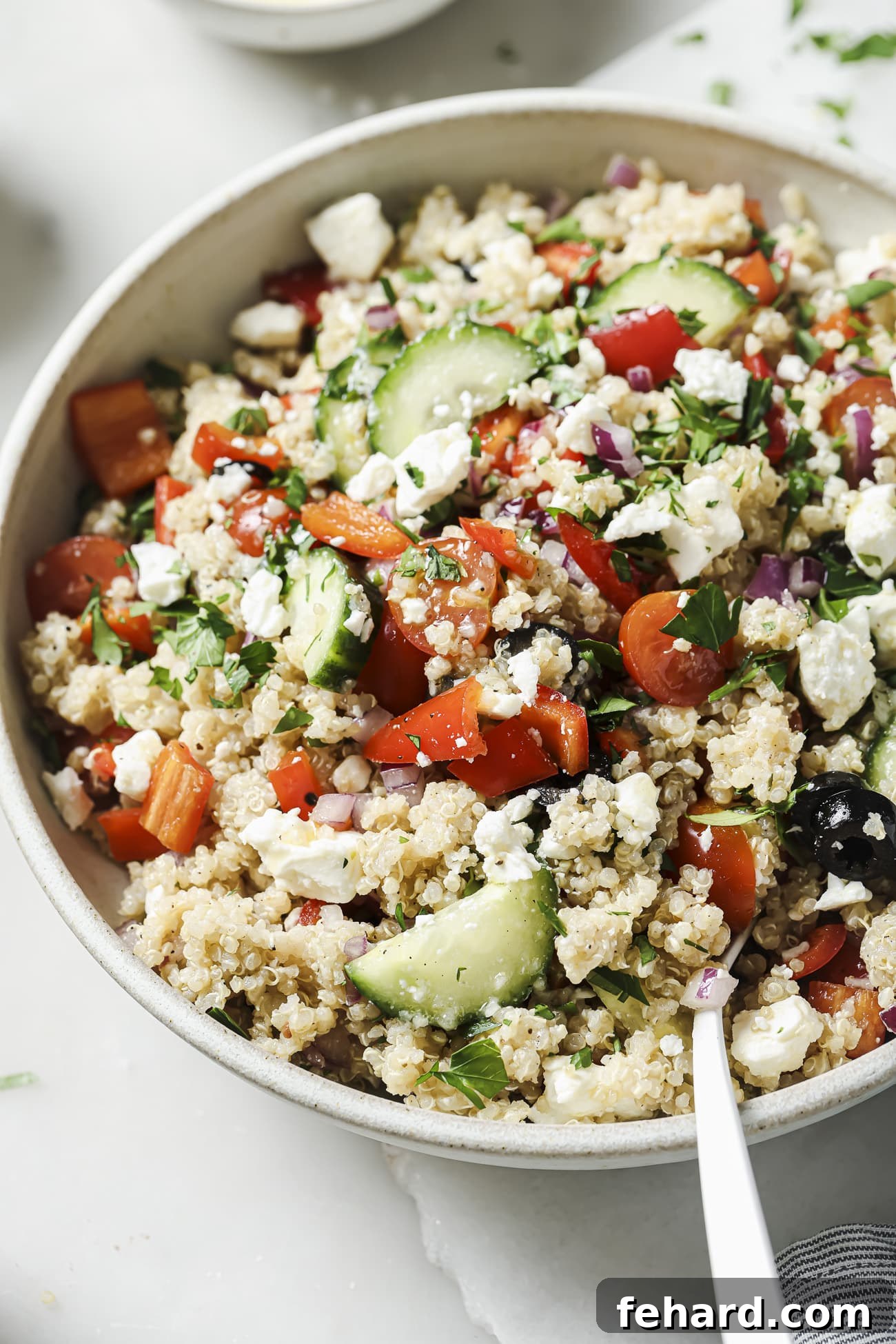 Vibrant Greek Quinoa Salad 6 A close-up shot of the finished Greek quinoa salad in a white bowl, ready to be enjoyed.