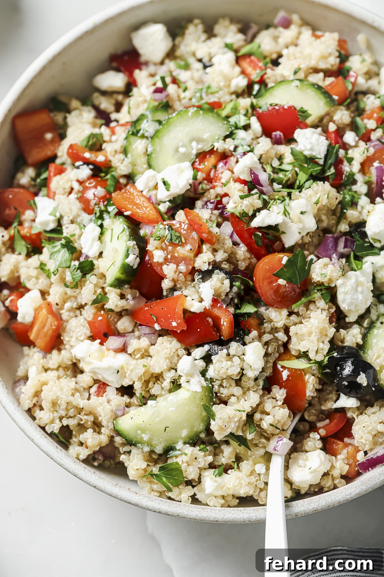 Vibrant Greek Quinoa Salad 7 A close-up of a refreshing Greek quinoa salad in a white bowl, perfect for a healthy meal.
