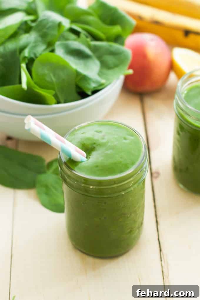 Close up of a mason jar of peach green smoothie, highlighting its inviting texture and color.