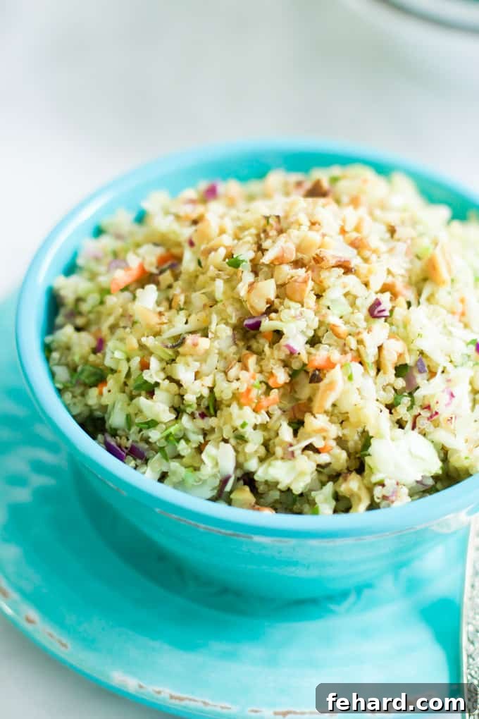 An angled, close-up photo of a vibrant quinoa cabbage salad in a teal bowl, highlighting the crisp cabbage and fluffy quinoa.