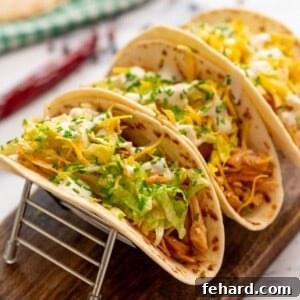 3 assembled buffalo chicken tacos on flour tortillas.