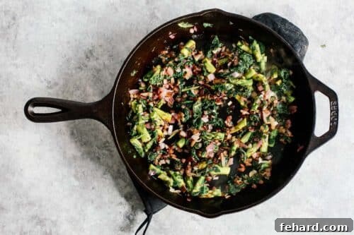 Overhead view of vegetables in an iron skillet sautéing.
