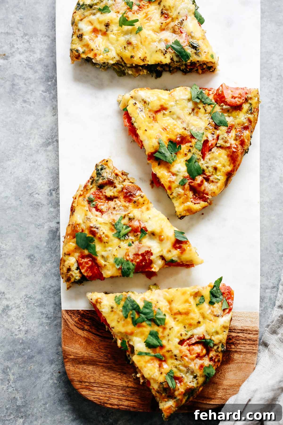 Close-up of individual slices of vegetable frittata, showcasing the vibrant colors of cherry tomatoes, kale, and asparagus embedded in the fluffy egg, ready to be enjoyed.
