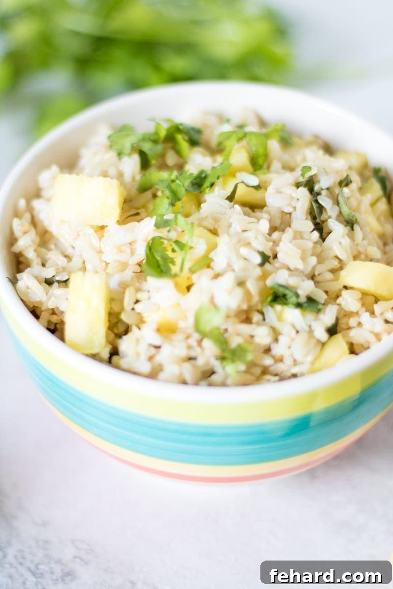 Close-up view of fluffy Pineapple Cilantro Lime Rice in a colorful serving bowl, ready to be enjoyed.