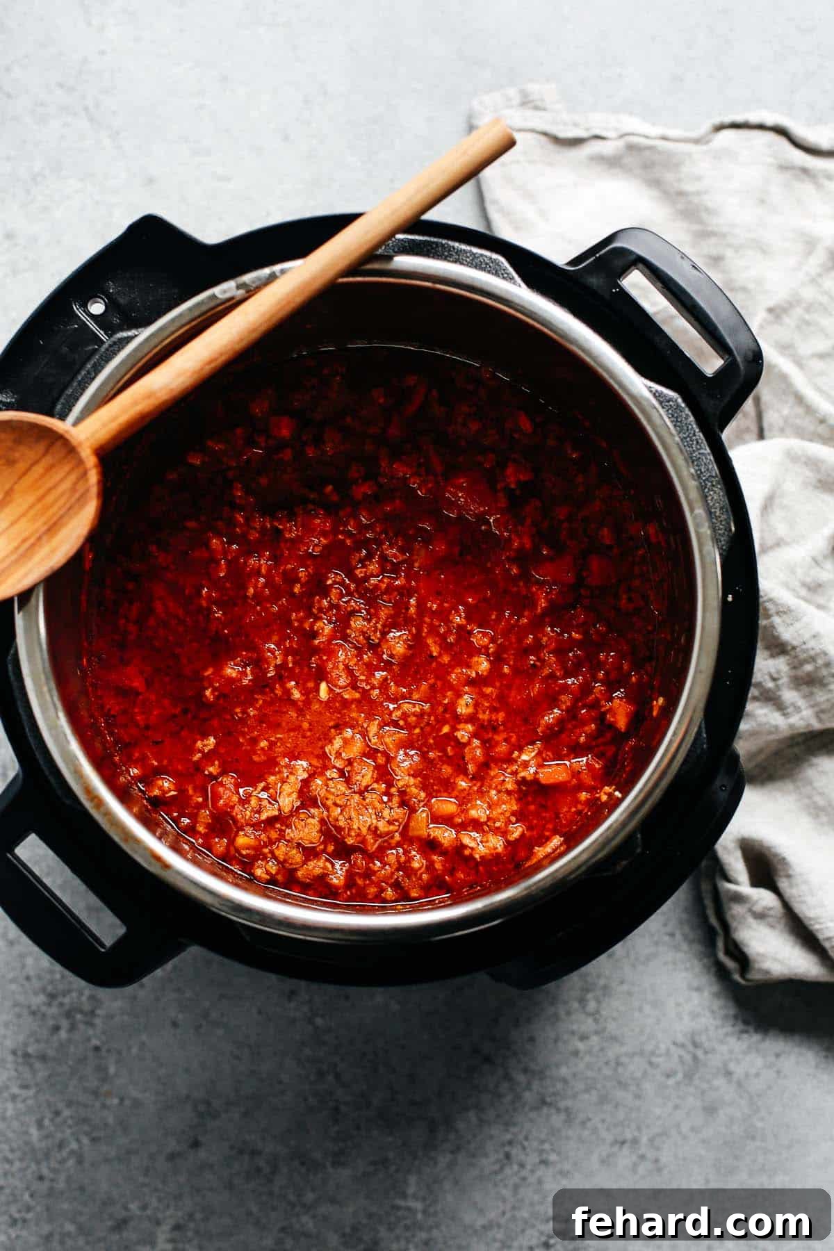 Instant Pot meat sauce simmering in an electric pressure cooker, showcasing its rich texture and vibrant color