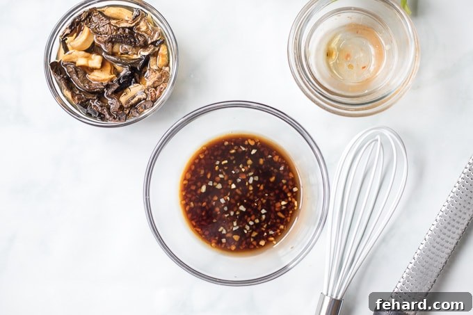A small bowl holding the mixed lettuce wrap sauce, positioned next to another dish where dried shiitake mushrooms are visibly soaking in hot water to rehydrate.
