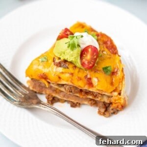 Slice of Instant Pot Taco Lasagna on white plate with Instant Pot in background.