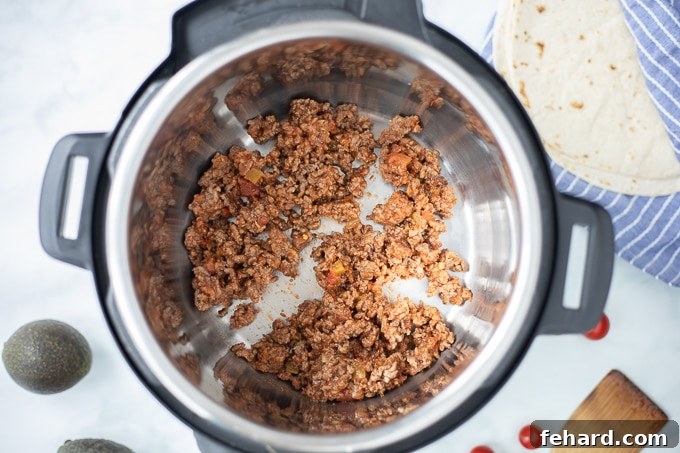 Instant Pot with perfectly browned and seasoned ground taco meat inside the inner pot, ready for the next step.