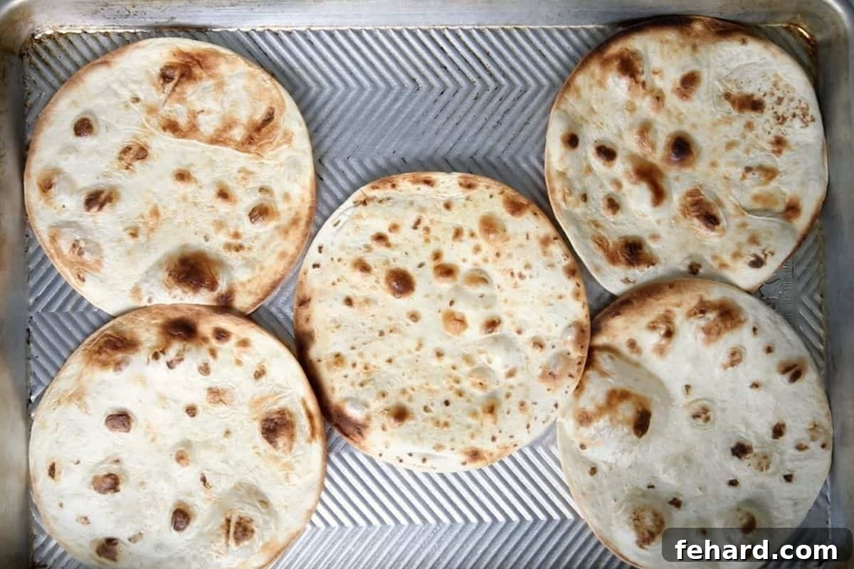 Crispy toasted tortillas laid out on a sheet pan, ready for assembly.