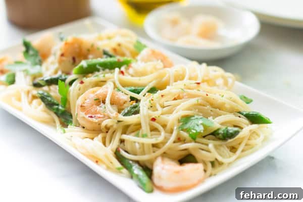 An angled image of a plate of garlic shrimp spaghetti, ready to be eaten.