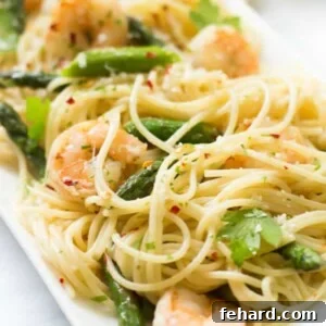 close up view of garlic shrimp spaghetti on a serving dish.