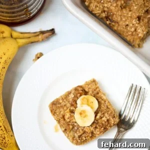 Slice of banana baked oatmeal on plate next to fork.