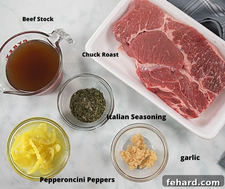 Pressure Cooker Italian Beef Recipe Ingredients Labeled ingredients for Italian Beef, including chuck roast, beef broth, pepperoncini, and various spices, arranged on a white countertop.