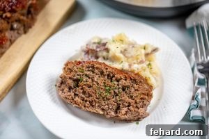 Sliced Meatloaf with mashed potatoes on white plate