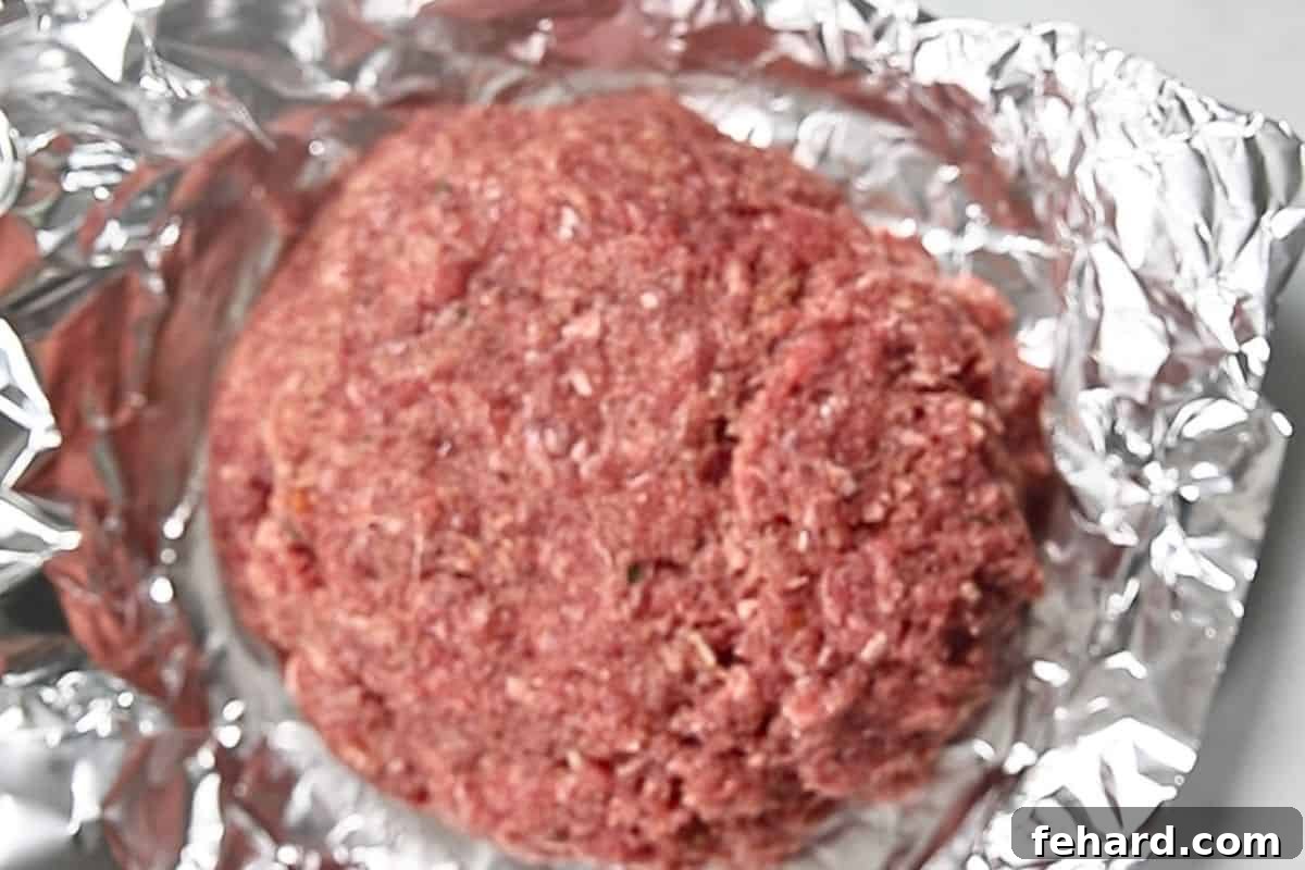 Meatloaf shaped on foil boat.