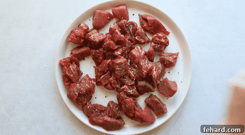 Fast and Flavorful Instant Pot Korean Beef 8 seasoned raw bee cubes on a white plate