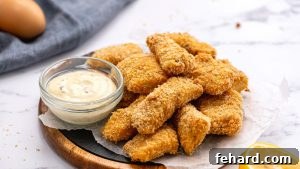 Baked fish sticks on platter with homemade tartar sauce