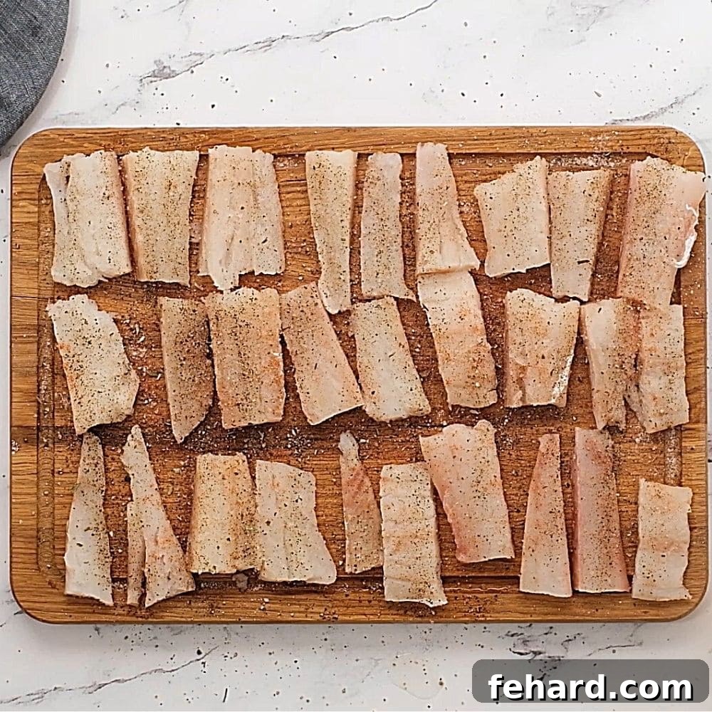 Seasoned fish sticks on wooden cutting boards.