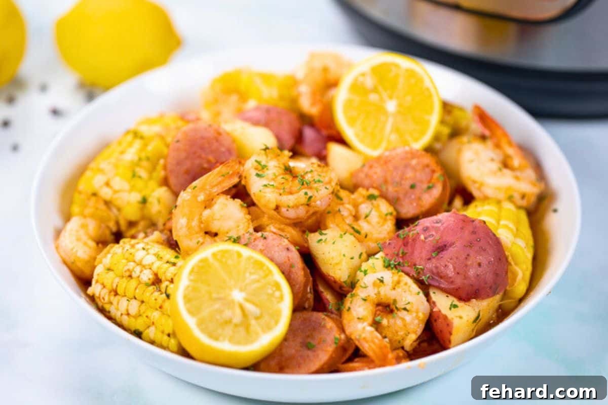 Instant Pot Shrimp Boil made with red potatoes, corn on the cob, and kielbasa in a white platter topped with parsley and fresh lemons next to Instant Pot.