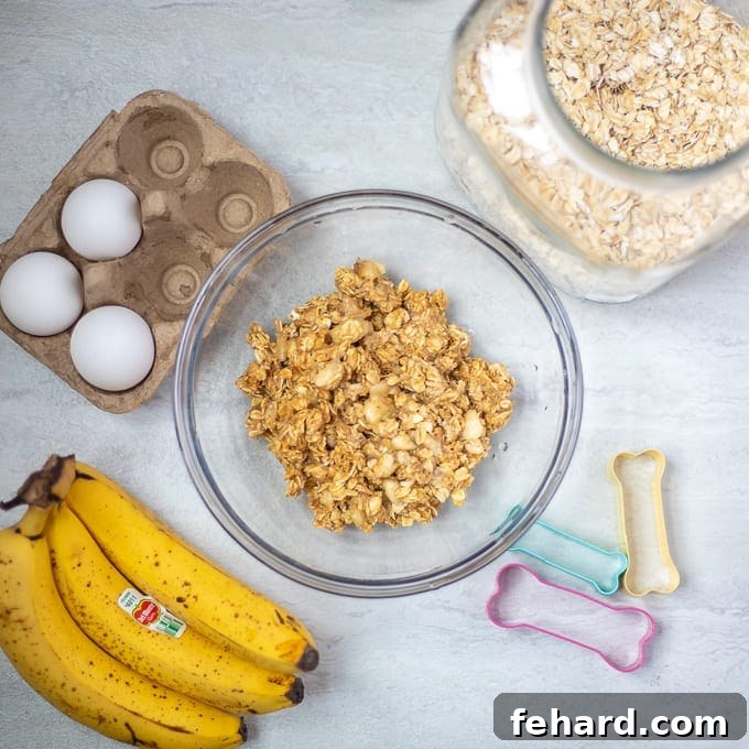 Bowl of homemade peanut butter dog treat batter with oats and bananas on the side