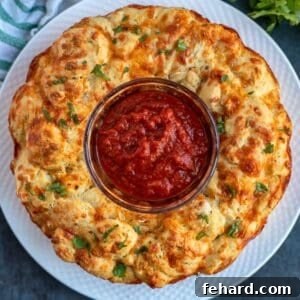 Pizza bread inverted on white plate topped with parsley and served with bowl of pizza sauce in middle of bread.