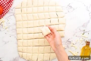 Pizza dough rolled out on floured surface cut into 1-inch cubes.