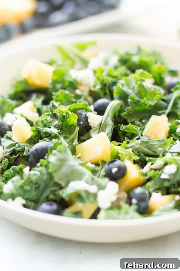 Kale Blueberry Pineapple Salad - A healthy and delicious salad rich in vitamins and fiber. Close-up of a refreshing blueberry pineapple kale salad, showcasing its vibrant ingredients.