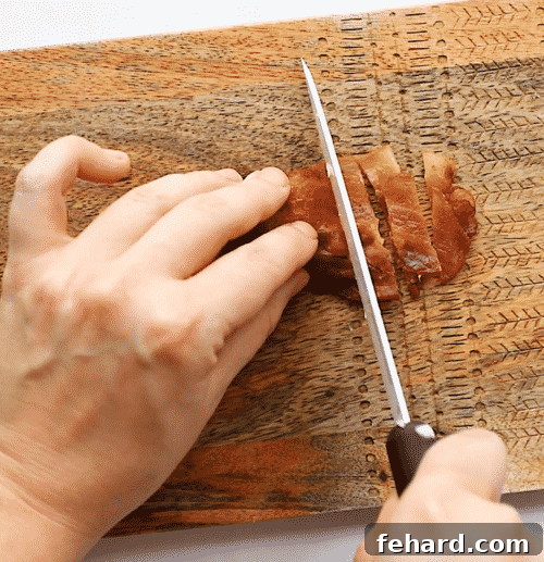 chopping bacon on a wooden cutting board