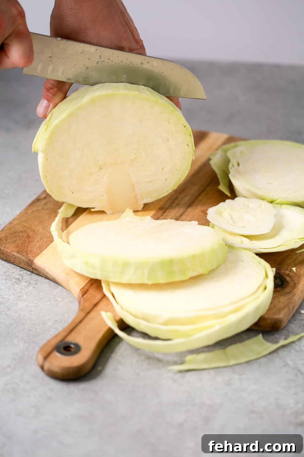slicing cabbage steaks on a cutting board