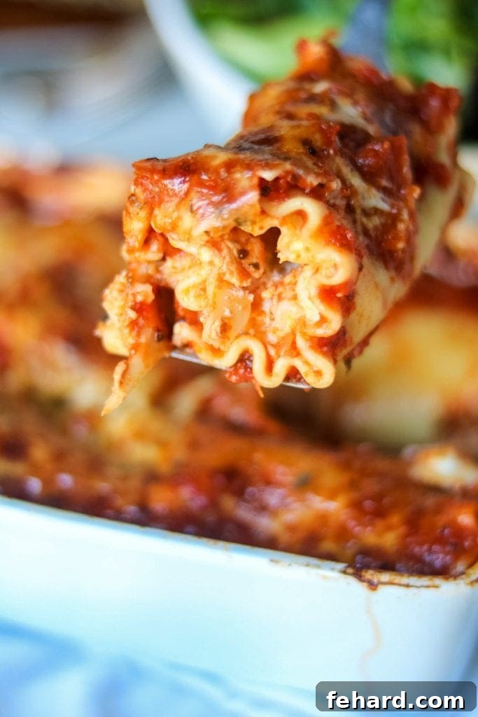 Savory Lasagna Whirls 2 A metal spatula dishing out a Lasagna Roll-Up from a baking dish, highlighting its cheesy and saucy layers.