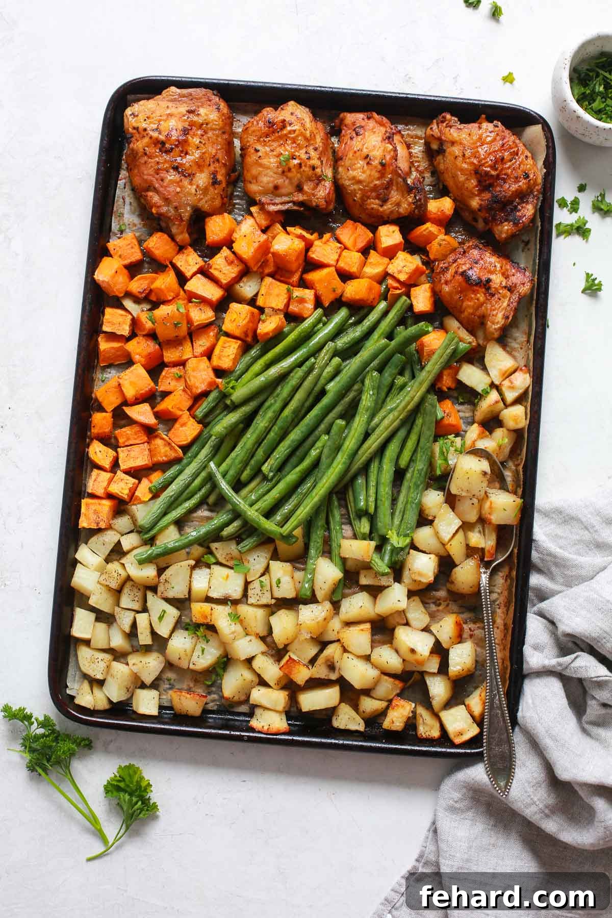 Golden Roasted Chicken and Garden Vegetables 2 Golden brown sheet pan chicken with roasted vegetables perfectly arranged on a baking sheet, ready to serve.