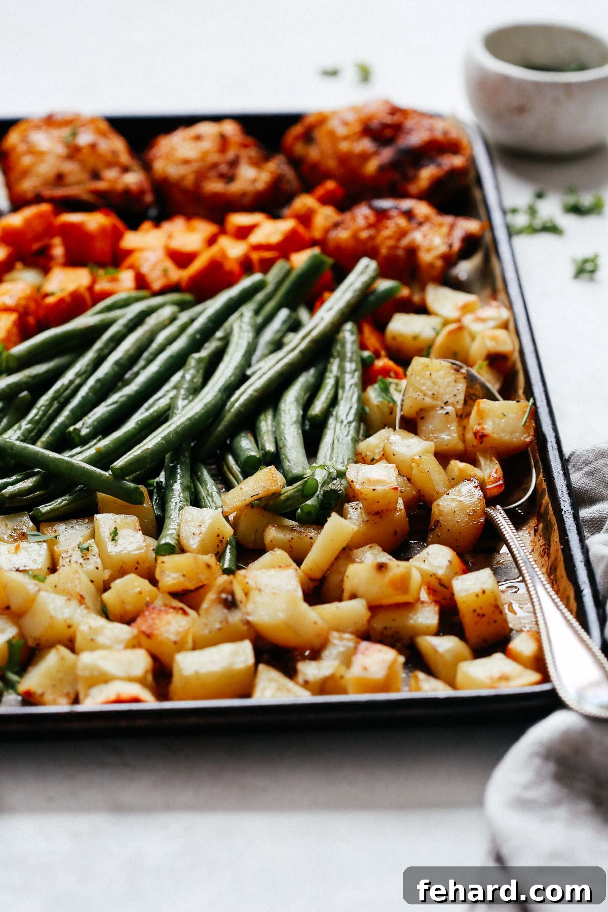 Golden Roasted Chicken and Garden Vegetables 3 Close-up view of perfectly roasted sheet pan chicken with tender, colorful vegetables on a baking sheet.